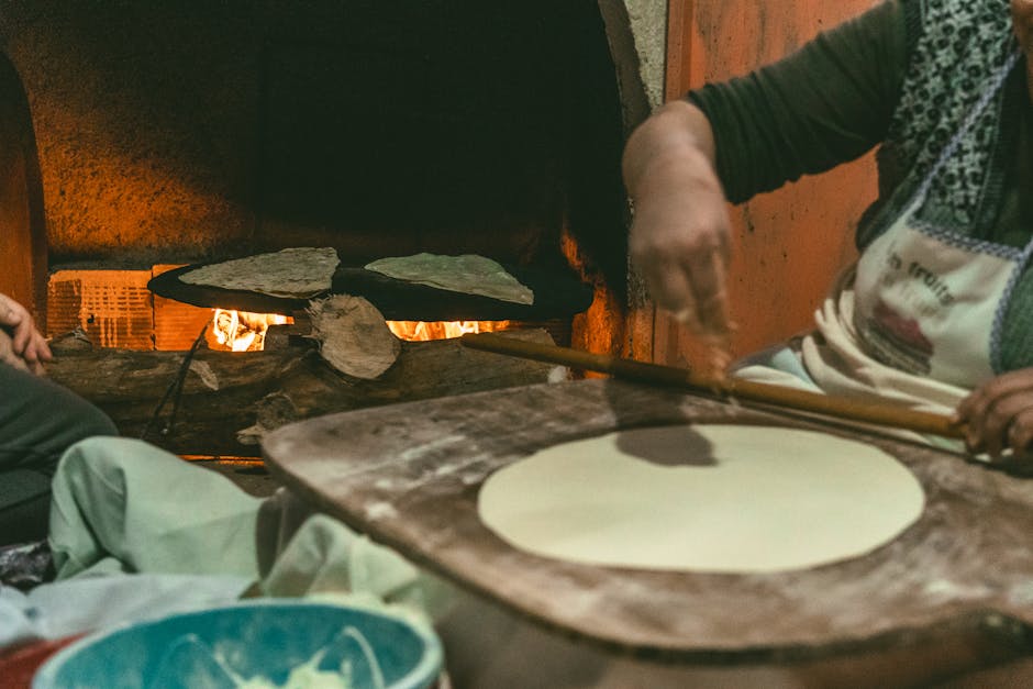 A warm scene of Turkish bread making in a traditional oven, captured indoors.