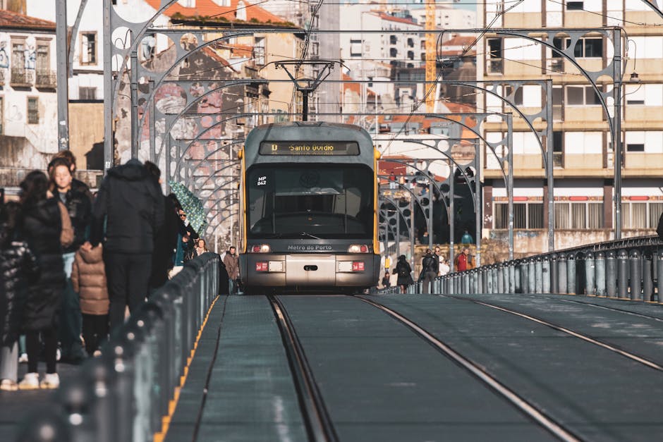 A metro tram traveling on the Ponte Luís I Bridge in Porto, Portugal, surrounded  urban architecture.