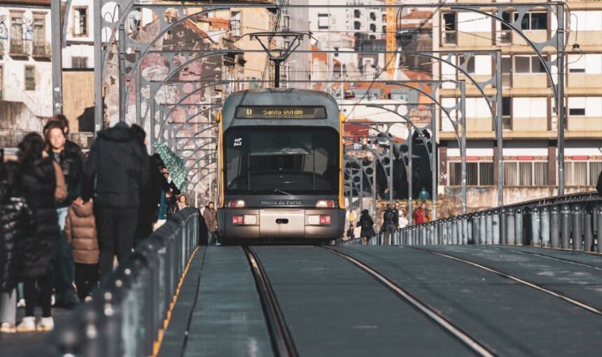 A metro tram traveling on the Ponte Luís I Bridge in Porto, Portugal, surrounded  urban architecture.