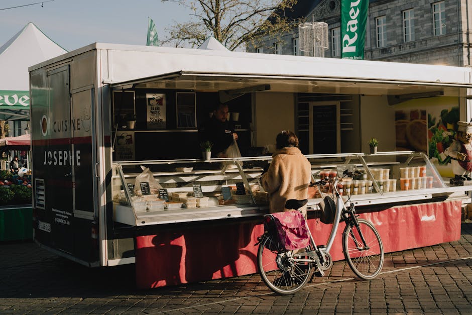 Uma mulher visita uma banca de comida de rua em Maastricht com a sua bicicleta.