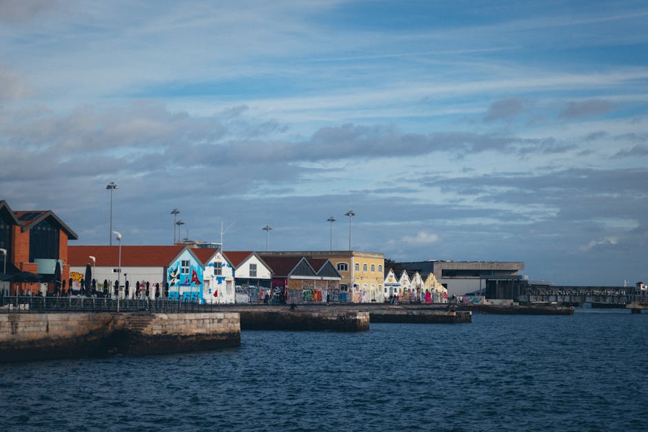 Scenic view of colorful buildings along a coastal town under a vibrant sky, perfect for travel themes.