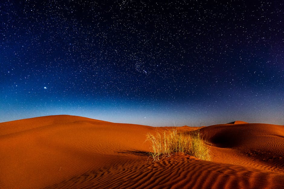 Céu noturno majestoso sobre dunas de areia na Província de Zagora, Marrocos, realçando a beleza da tranquilidade da natureza.