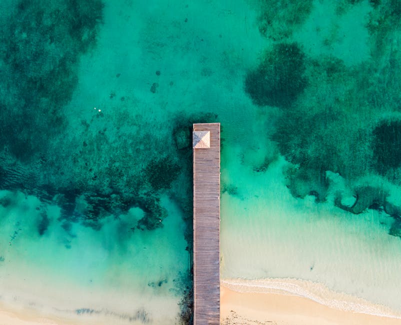 Vista aérea deslumbrante de um cais de madeira a estender-se pelas águas azul-turquesa de Ocho Rios, Jamaica.