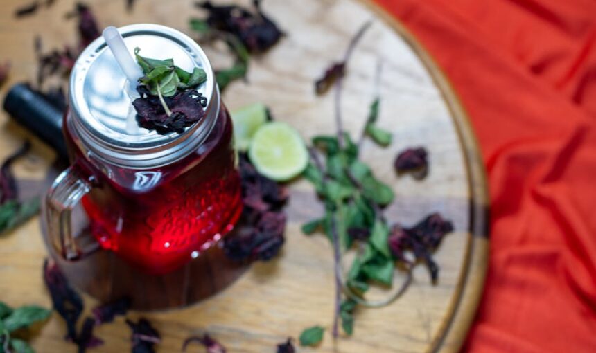 Vista aérea de Água de Jamaica com lima e hortelã sobre uma superfície de madeira.