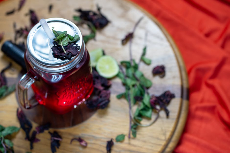 Vista aérea de Água de Jamaica com lima e hortelã sobre uma superfície de madeira.