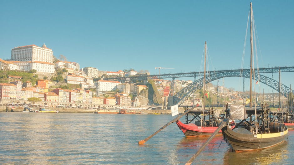 Vista panorâmica dos edifícios coloridos do Porto e barcos tradicionais no Rio Douro.