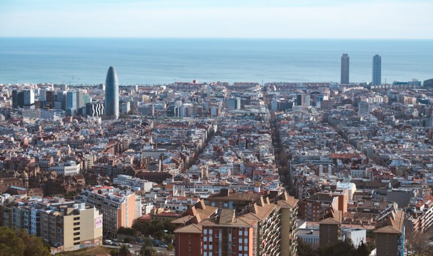 Vista aérea panorâmica da paisagem urbana de Barcelona, mostrando o Mar Mediterrâneo e a arquitetura icónica.