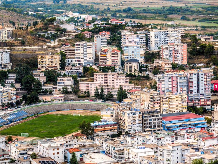 Vista aérea de Gjirokastër, Albânia, mostrando a paisagem urbana densamente povoada e o estádio.