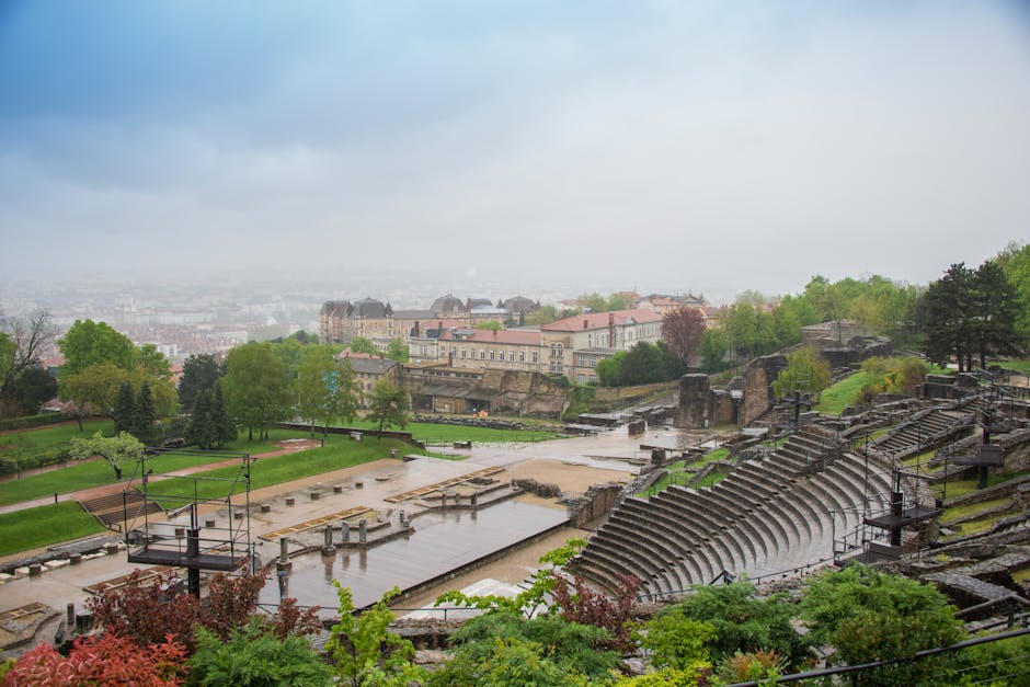 Vista do antigo anfiteatro romano em Lyon com a paisagem urbana circundante, céu nublado.