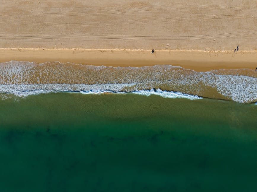 Espetacular vista aérea da praia de Lagos com águas cristalinas azul-turquesa e areia dourada no Distrito de Faro, Portugal.
