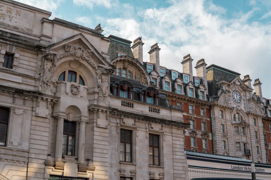 Fachada elegante da Estação Victoria em Londres, capturando a beleza arquitetónica clássica sob o céu diurno.