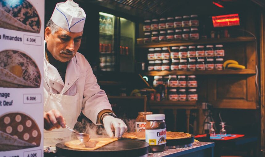 A chef prepara habilmente um crepe de Nutella num acolhedor café parisiense. Ambiente interior e perícia culinária.