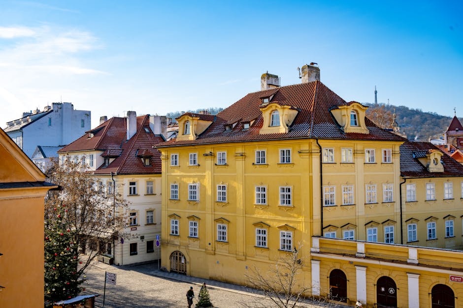 Vista de edifícios históricos coloridos em Praga com um céu azul como pano de fundo.