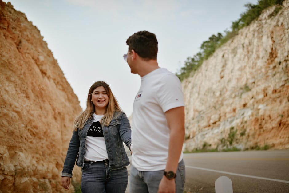 Um casal sorridente de mãos dadas a passear por uma estrada pitoresca em Tuxtla Gutiérrez, México.