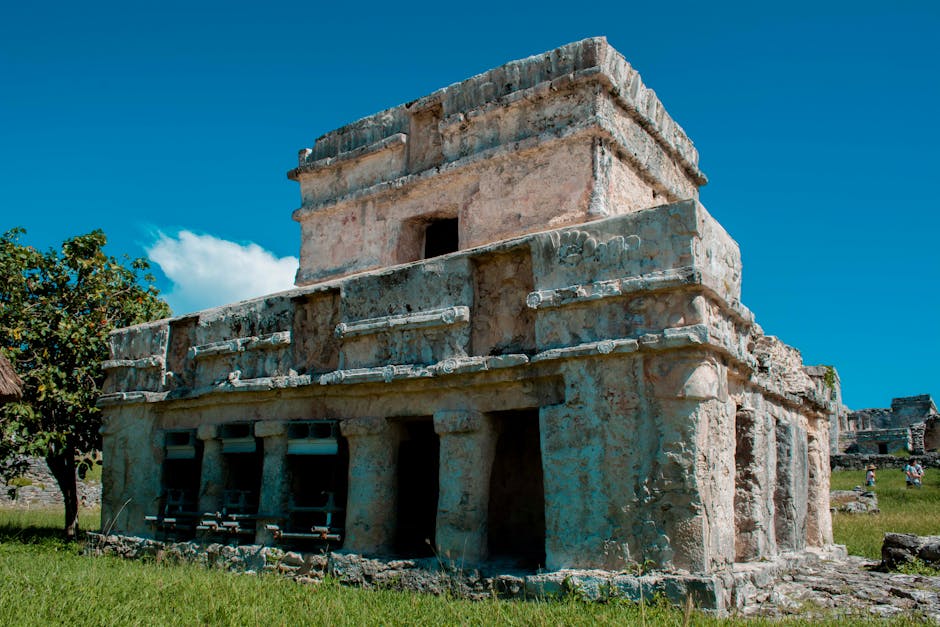 Explore as ruínas antigas de Tulum, exibindo arquitetura maia sob um céu azul brilhante.