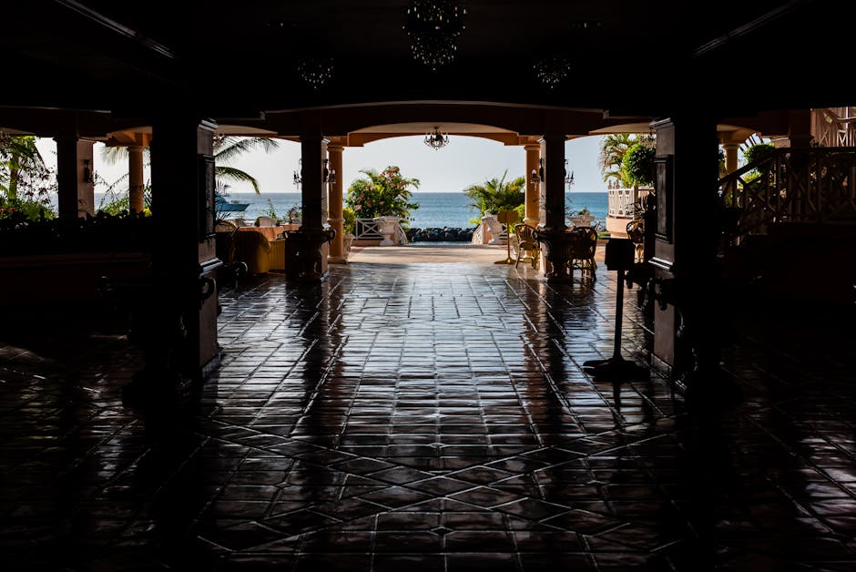 Vista deslumbrante do Mar das Caraíbas, emoldurada por um pátio com reflexos no chão de azulejos.