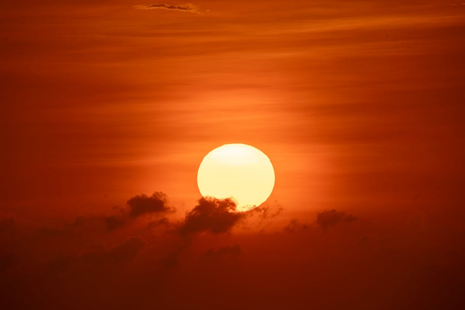 Um pôr do sol deslumbrante sobre Bali, com um sol vibrante e nuvens flamejantes no céu.