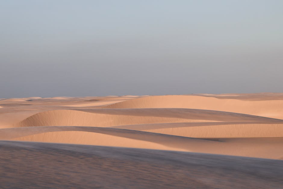 Dunas de areia brilhantes sob um céu límpido no Parque Nacional dos Lençóis Maranhenses, no Brasil.