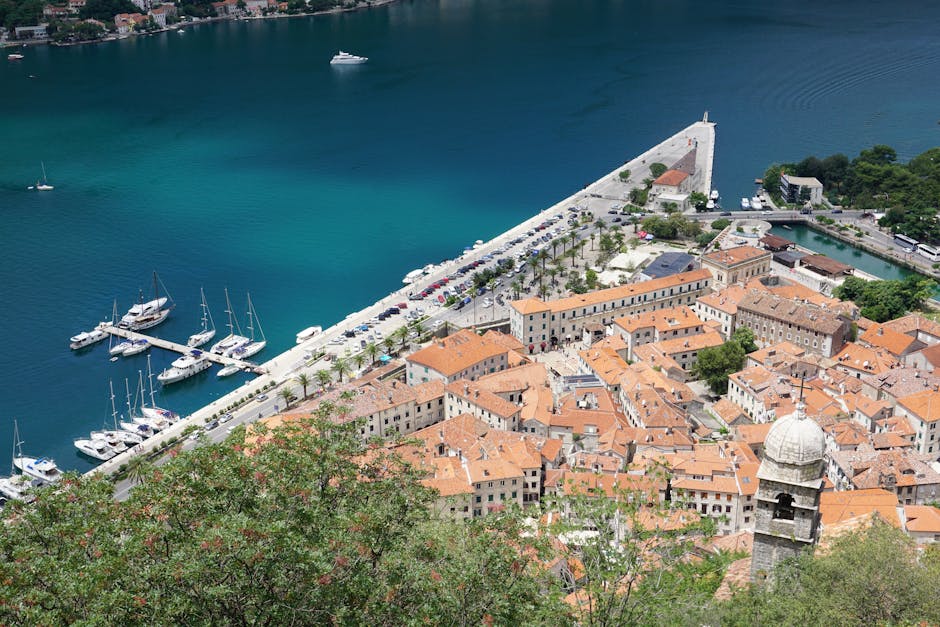 Uma vista aérea deslumbrante da cidade velha e da marina de Kotor, no Montenegro, sob um céu azul límpido.