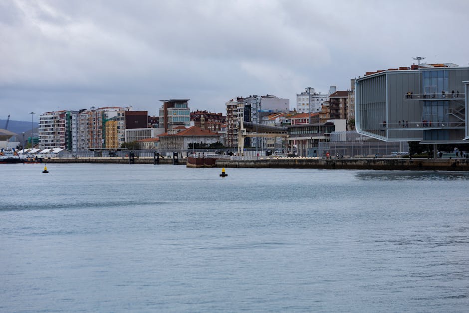 Vista panorâmica dos edifícios da frente ribeirinha de Santander sob um céu nublado.