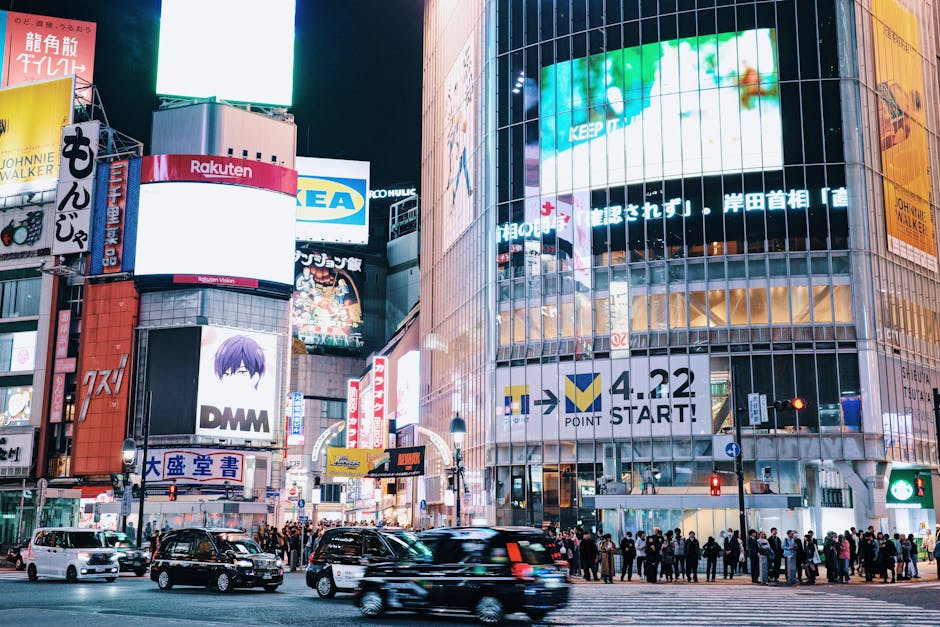 O movimentado Cruzamento de Shibuya em Tóquio, iluminado à noite com multidões e letreiros de néon.