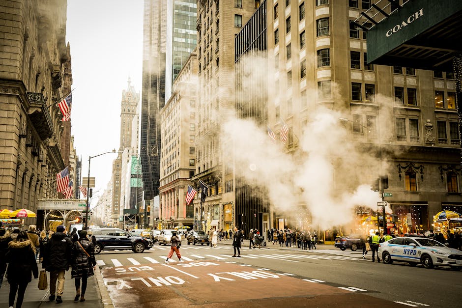 Cena urbana movimentada em Nova Iorque, com peões, trânsito e vapor a sair das tampas de esgoto.