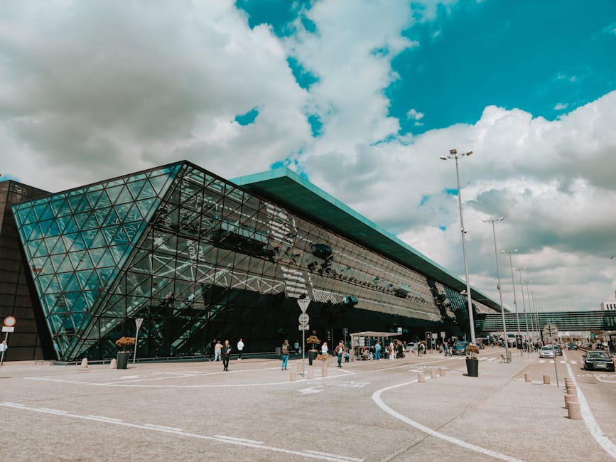 Terminal de aeroporto contemporâneo com uma impressionante fachada de vidro sob um céu nublado.