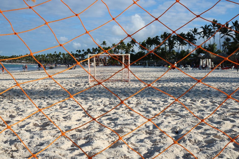 Rede de futebol laranja numa praia de areia em Punta Cana, República Dominicana, perfeita para um cenário desportivo tropical.