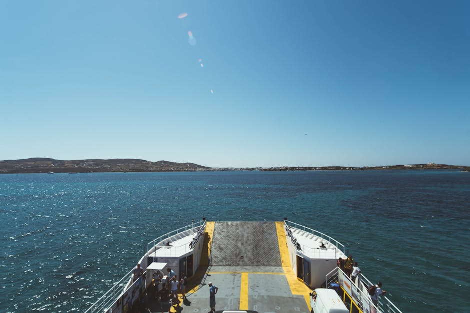 Um passeio de ferry tranquilo num dia soalheiro com um céu azul límpido e o horizonte do oceano.