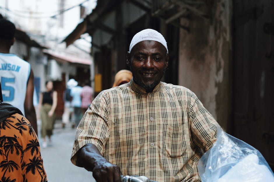 Um homem anda de bicicleta pelas ruas movimentadas de Stone Town, Zanzibar.