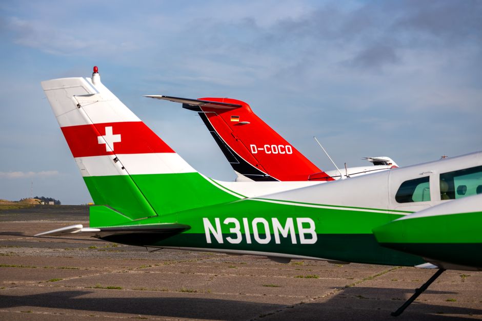 Pontas de cauda de avião vibrantes no asfalto, a realçar o design e o contraste de cores da aviação.