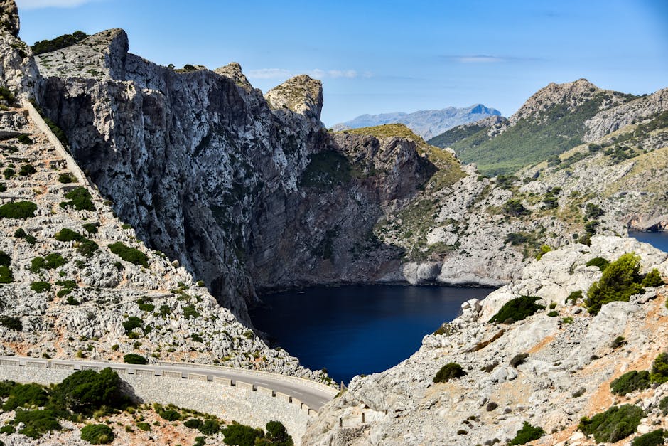 Vista deslumbrante da costa acidentada de Maiorca, com falésias íngremes e uma estrada sinuosa nas Montanhas Tramuntana.