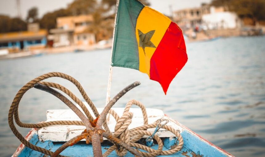 Bandeira senegalesa colorida e cordas náuticas no convés de um barco, perfeitos para temas de viagem.