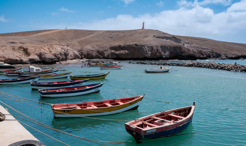 Cena animada de barcos de pesca coloridos ancorados nas águas serenas de Pedra Lume, Sal, Cabo Verde.