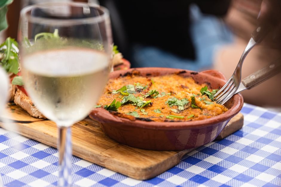 Um delicioso prato português servido com vinho branco num restaurante em Faro, Portugal.